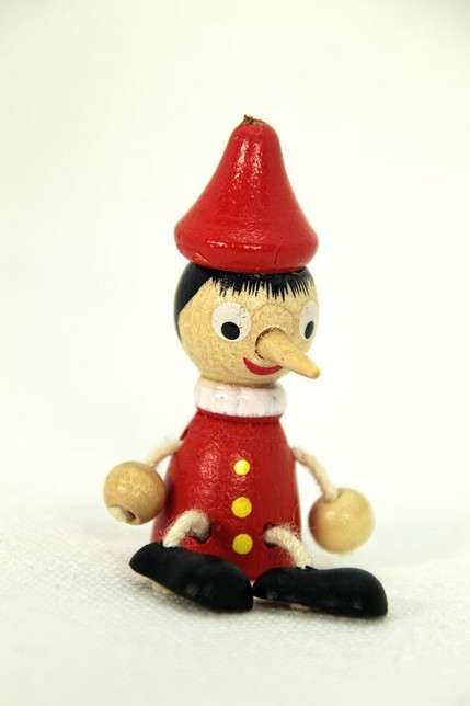 A toy figurine of a boy with a red hat