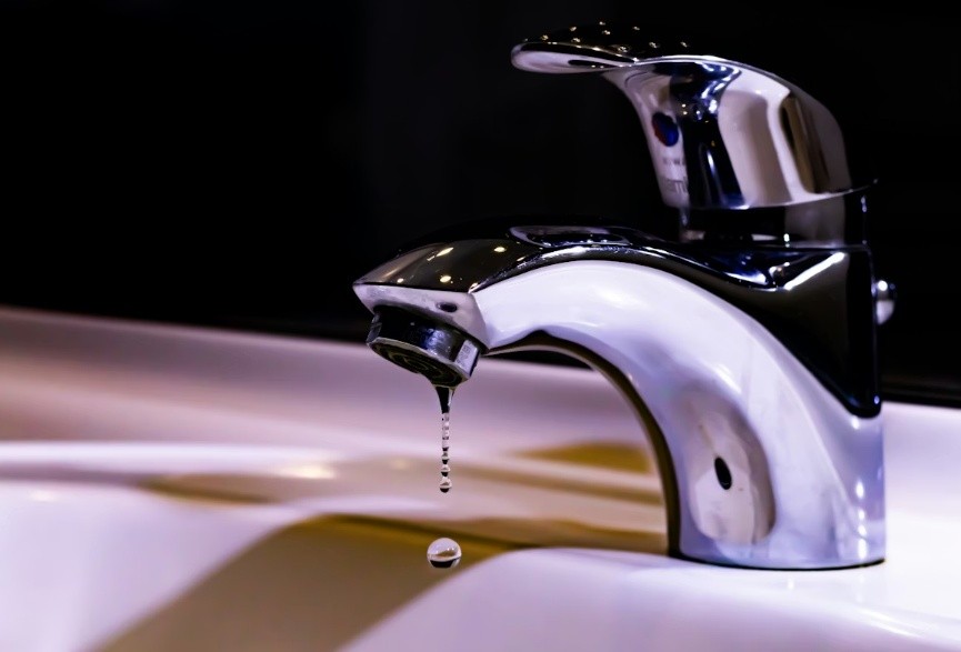 Stainless steel faucet on white ceramic sink
